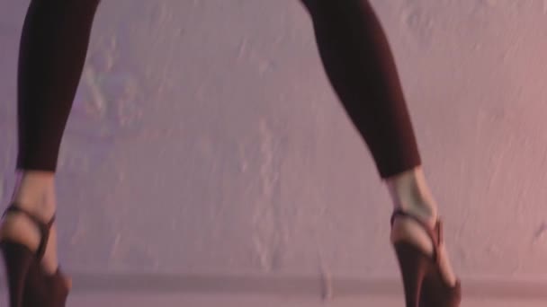 Nahaufnahme für schwarze Schuhe für Pole Dance mit High Heels an den Beinen einer Tänzerin, modernes Tanzkonzept. Aktion. Eine Frau bewegt sich auf Stöckelschuhen im Studio gegen die Wand. — Stockvideo