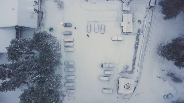 Vue aérienne de la maison couverte de neige, des voitures stationnées et des pins verts en hiver. Clip. Cour vide par temps d'hiver givré . — Photo