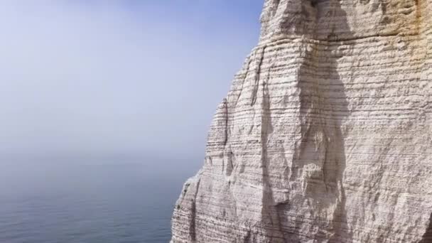 Flygbild av en vacker vit klippa på molnigt blå himmel bakgrund, resa attraktion. Åtgärder. Jätte brant klippa över det lugna havet med människor som går på toppen. — Stockvideo