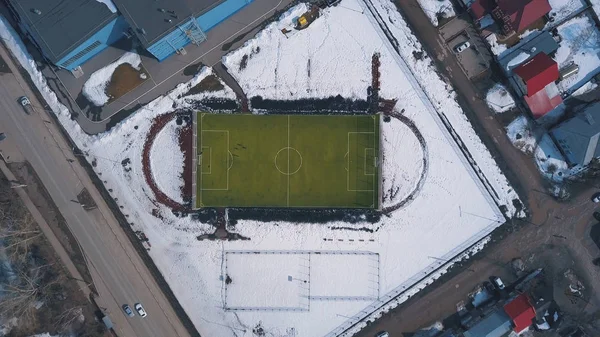 Aerial view of green football field and people playing football in winter. Clip. Hard trainings in winter season — 스톡 사진