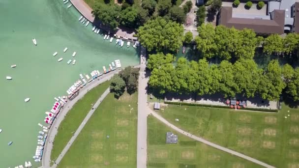 Vista aerea superiore del canale della città con barche turistiche, alberi verdi e case in una giornata di sole estivo. Azione. Bellissimo paesaggio del fiume turchese con piccoli yacht vicino al parco cittadino . — Video Stock