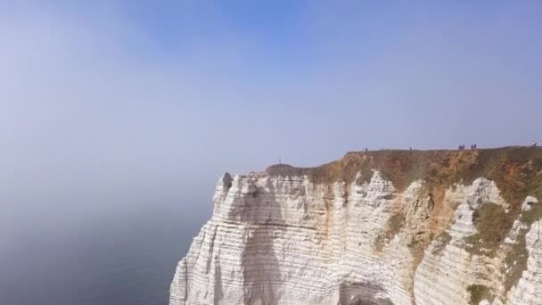 Pareja viajando juntos en el borde del acantilado blanco en el fondo del cielo azul, concepto de estilo de vida. Acción. Pareja joven de viajeros en una colina con impresionantes vistas del océano . — Vídeo de stock