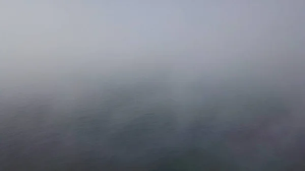 Fliegt mit einem verliebten Paar über die Klippe in den blauen wolkenverhangenen Himmel über dem Wasser. Aktion. Luftaufnahme des Meeres mit dem Horizont, der hinter den Wolken versteckt ist. — Stockfoto