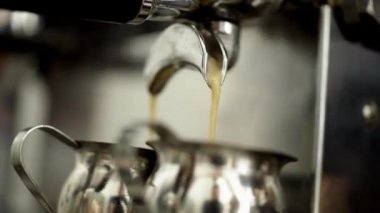 Kahve makinesinin yakın çekim iki kupa kahve döker. Eylem. Kokulu sıcak kahve iki beyaz kupalar profesyonel coffe pişirme dökülür