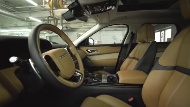 Inside new cars expensive leather interior. Action. Modern interior trim design of new car finishing enterprise car production — Stock Video