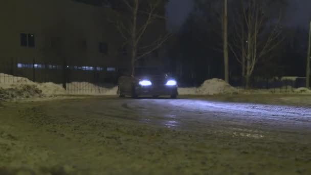 Vackra lila passagerar bil driver i stadens gator på natten under vintersäsongen. Åtgärder. En bil som går in i en sladd med smuts som flyger från under hjulen. — Stockvideo
