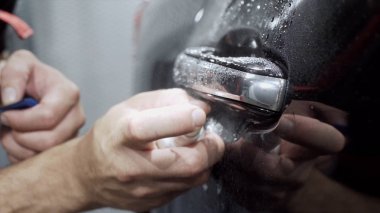 Araba sapı temizliğinin yakın çekim. Eylem. Pahalı araba işçisi profesyonel oto yıkama kapı kolu kapsamlı temizlik