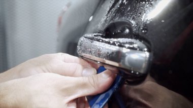 Araba sapı temizliğinin yakın çekim. Eylem. Pahalı araba işçisi profesyonel oto yıkama kapı kolu kapsamlı temizlik