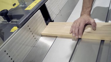 Taşlama makinesinde işçi işlemlerinin yakın çekim ahşap panoları. Eylem. Ahşap işçilik veya mobilya fabrikasında endüstriyel taşlama makinesi