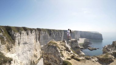 Beyaz kayalar ve mavi deniz ve berrak gökyüzü ile plaj arka planda öpüşme Loving çift. Eylem. Beyaz kayaların güzel manzara arka plan üzerinde öpüşme tatilde Turist çift
