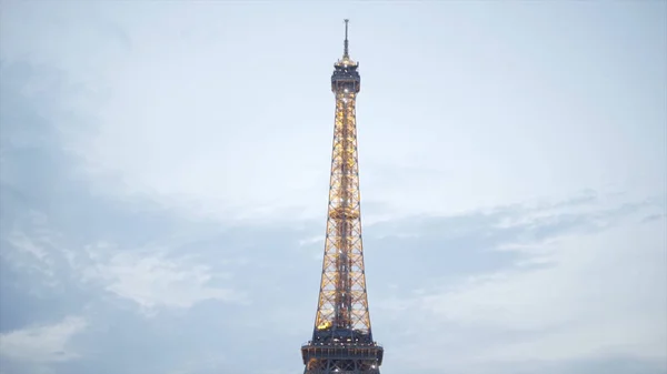 Turistas na brilhante Torre Eiffel à noite. Acção. Muitos turistas sentam-se no gramado e desfrutam de uma bela vista da brilhante torre Eiffel à noite no verão — Fotografia de Stock