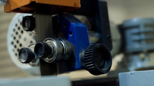 Máquina de sierra de cinta de corte en planta de carpintería. Acción. Primer plano de la máquina de sierra de cinta profesional en movimiento antes de cortar madera en la empresa industrial de carpintería —  Fotos de Stock