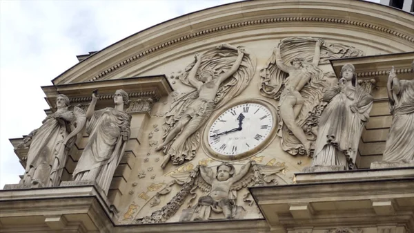 Bella vecchia cappella con statue in rilievo. Azione. Magnifiche statue e rilievi di dee in piedi sotto arco con orologio in cima — Foto Stock