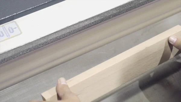 Κοντινό-up των εργαζομένων επεξεργάζεται ξύλινες σανίδες στο μηχάνημα λείανσης. Δράση. Βιομηχανικό μηχάνημα λείανσης σε ξυλουργικό ή εργοστάσιο επίπλων — Φωτογραφία Αρχείου