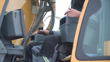 Engineer operator crane in action. Clip. Man in cabin controls the crane. He sit a top in crane cabin and working clipart