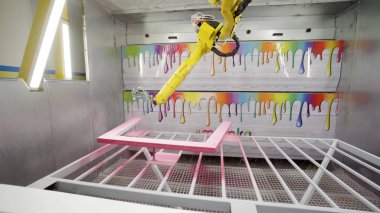 Endüstriyel robotik kol boyaları çerçeve. Eylem. Endüstriyel işletmelerde mobilya boyama için modern ekipman. Robotik kol boyalar sprey boyalı ahşap çerçeve pembe