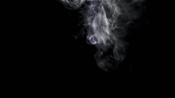 Getti di fumo bianco su sfondo nero. Azione. Nube di fumo bianco sorge su sfondo nero ed evapora — Foto Stock