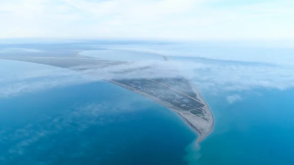 Bovenaanzicht van de kust tussen zee op achtergrond van Sky horizon. Shot. Het hoogste uitzicht in de hemel tussen wolken op de blauwe zee en de driehoekige oever — Stockfoto