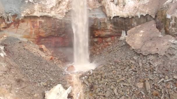 View of waterfall on background of dirty mineral rock. Stock. Dirty waterfall trickle down mineralogical brown rock wall with landslide remains — Stock Video