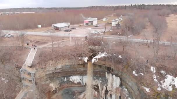 Vuile lente waterval met toeristen. Voorraad. Top uitzicht van vuile waterval stroomt naar beneden bos berg met smeltende sneeuw en wandelen toeristen. Vuile waterval na sneeuw smelt in het vroege voorjaar — Stockvideo