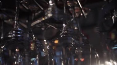 Bar tezgahında asılı şarap ve diğer alkollü içecekler için boş bardaklar. Çerçeve. Şarap bardaklarının bulanık görünümü