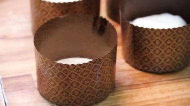 Ahşap bir masada yatan Paskalya pastası için kağıt Bakeware için yakın, Ortodoks tatil kavramı. Stok görüntüleri. Paskalya pastası hazırlanması, kahverengi kağıt paketleme.