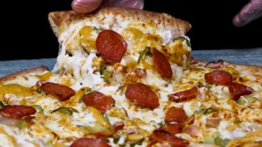 Lezzetli pepperoni pizza, foodporn dilim çekme el için yakın. Çerçeve. Siyah arka planda sıcak İtalyan pepperoni pizza.