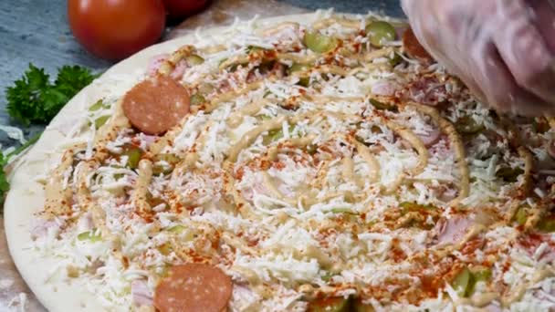 Chef cocinando pizza de salami, usando guantes de cocina, concepto foodporn. Una trampa. Cierre para las manos poniendo salami en la pizza antes de hornear . — Vídeos de Stock