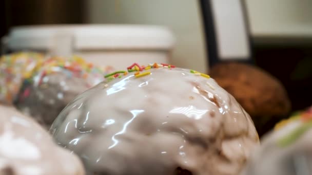 白い釉薬とカラフルな菓子の振りかける、正統な休日のコンセプトで飾られた焼きたてのイースターケーキをクローズアップ。ストック映像。ケーキの上に落ちる振りかける. — ストック動画