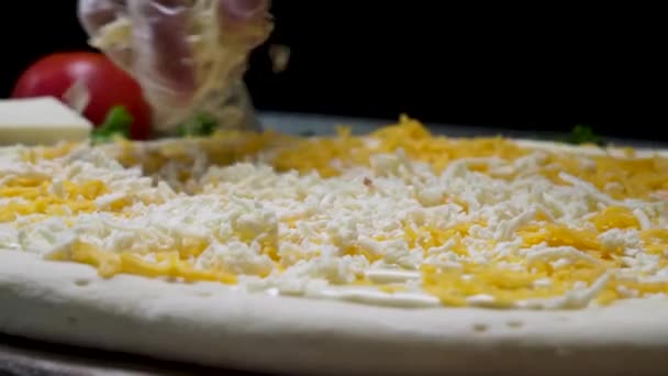 Close up para cozinheiros mãos em luvas de cozinha colocando queijo na pizza Quatro queijos. Moldura. Chef adicionando os ingredientes para a pizza, produção e entrega de alimentos . — Vídeo de Stock