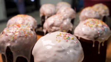 Paskalya pastası beyaz şeker sır, renkli şeker şeker, Mutlu Paskalya kavramı ile dekore edilmiştir. Stok görüntüleri. Pasta üzerinde yavaş hareket düşen şekerleme Sprinkles için yakın.