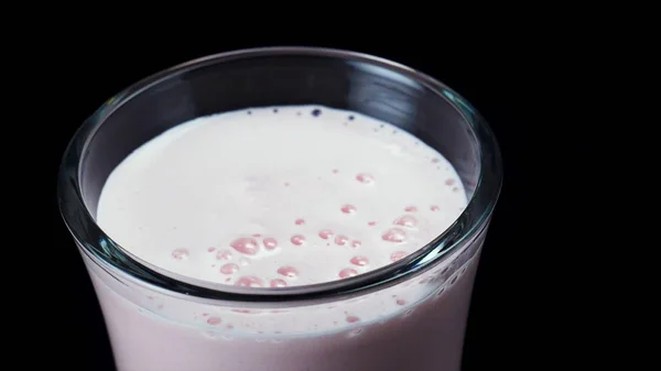 Uzavřete sklenici plnej jahodového koktejtu izolovanou na černém pozadí. Rámeček. Růžový nápoj ve sklenici, zdravá letní představa. — Stock fotografie