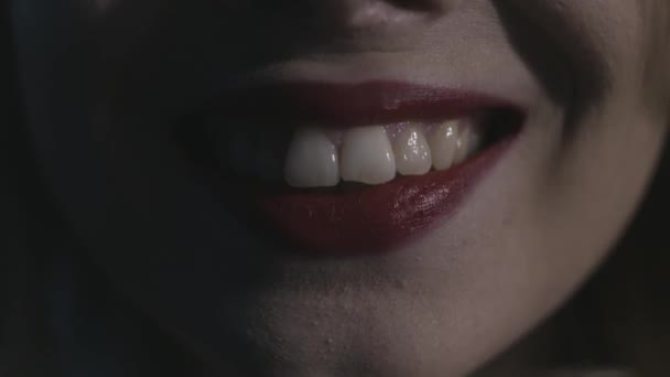 Extreme Nahaufnahme für sexy Frauenlippen mit rotem Lippenstift, wunderschönem Lächeln, Gesichtsparts. Aktion. rote sinnlich lächelnde Lippen auf schwarzem Hintergrund, Kosmetik, Zahnheilkunde und Kosmetikkonzept. — Stockvideo