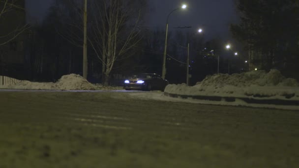 Зимний автомобиль дрейфует по городской улице ночью, концепция автоспорта. Начали. Пассажирское транспортное средство, въезжающее в занос по заснеженной дороге . — стоковое видео