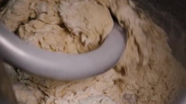 Üretim mikserinde yoğuran hamurun yakın çekim. Stok görüntüleri. Spiral yoğurma fırında pişirme için taze hamur yoğurunur