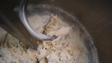 Mikserde yoğuran hamurun yakın çekim. Stok görüntüleri. Fırınlarda pasta üretimi için spiral karıştırıcılar üretim ekipmanları
