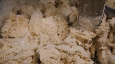 Mikserde yoğuran hamurun yakın çekim. Stok görüntüleri. Fırınlarda pasta üretimi için spiral karıştırıcılar üretim ekipmanları