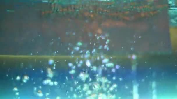 Primer plano de burbujas en el tanque de agua con iluminación. Una trampa. Hermosa gran corriente de burbujas que suben a la superficie del acuario con luces brillantes — Vídeos de Stock