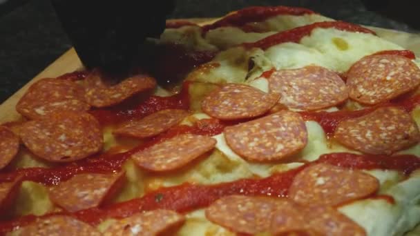 Primer plano del chef preparando pepperoni pizza. Una trampa. Chef en guantes pone rebanadas de salchicha de pepperoni en pizza cruda antes de freír. Cocina italiana pizza — Vídeo de stock