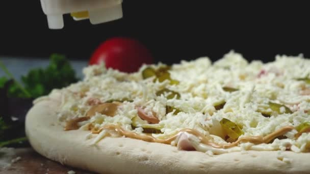 Close-up van chef bereidt Italiaanse pizza. Frame. Professionele chef-kok giet fles met gemengde saus op heerlijke pizza. Koken Italiaanse pizza op zwarte geïsoleerde achtergrond — Stockvideo