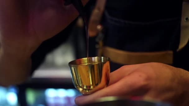 Крупним планом бармен готує алкогольний напій у барі. Рамка. Бармен вливає сироп у мірну чашку, щоб зробити коктейль у пабі — стокове відео