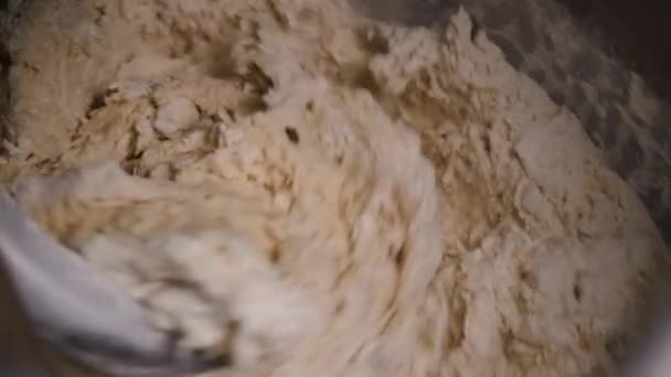 Close-up van het kneden van het deeg in productie mixer. Stock footage. Spiral kneder kneedt vers deeg voor bakken in bakkerij — Stockvideo