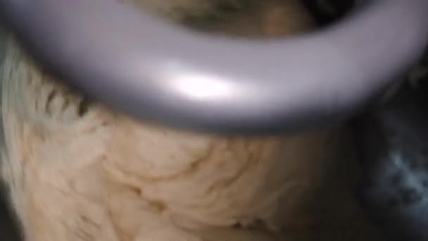 Gros plan de la pâte pétri dans le mélangeur dans la boulangerie. Images d'archives. La pâte à air est malaxée dans un mélangeur de pâte industriel à l'usine de pain ou à la boulangerie 