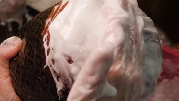 アイシングでカップケーキをカバー。ストック映像。手袋のパン屋はイースター休暇のためのレーズンと白いクリームカップケーキを釉薬 — ストック動画