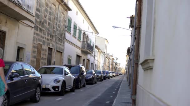 Vue sur les rues étroites de la ville européenne en été. L'art. Promenades de femme avec chien dans la rue étroite avec rangée garée de voitures en vacances d'été — Video