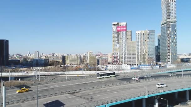 Vista superior de la gran ciudad con edificios de gran altura y tráfico en las carreteras. Escena. Hermosa metrópolis durante el día está inmersa en el tráfico bullicioso en las carreteras de la ciudad — Vídeos de Stock