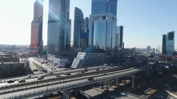 Top view of business center in metropolis with traffic on roads. Scene. Beautiful day city landscape with glass skyscrapers of business centers and people hurrying to work in cars — Stock Video