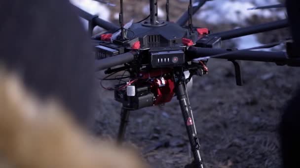 Primer plano de los hombres preparados quadcopter para el vuelo. Clip. Dos hombres admiran la última versión del quadcopter con potentes motores y cámara profesional para la fotografía desde el aire — Vídeos de Stock