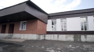 Küçük fabrikanın dış görünümü. Eylem. Bazı malzemelerin işlenmesi veya üretimi için küçük işletmelerin eski binasının cephesi