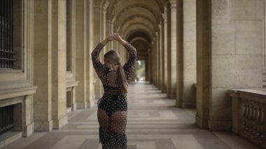 Seksi genç kadın eski bina yürüyüş geri görünümü. Eylem. Baştan çıkarıcı şeffaf elbise çekici genç kadın eski binanın koridorboyunca model yürüyüş